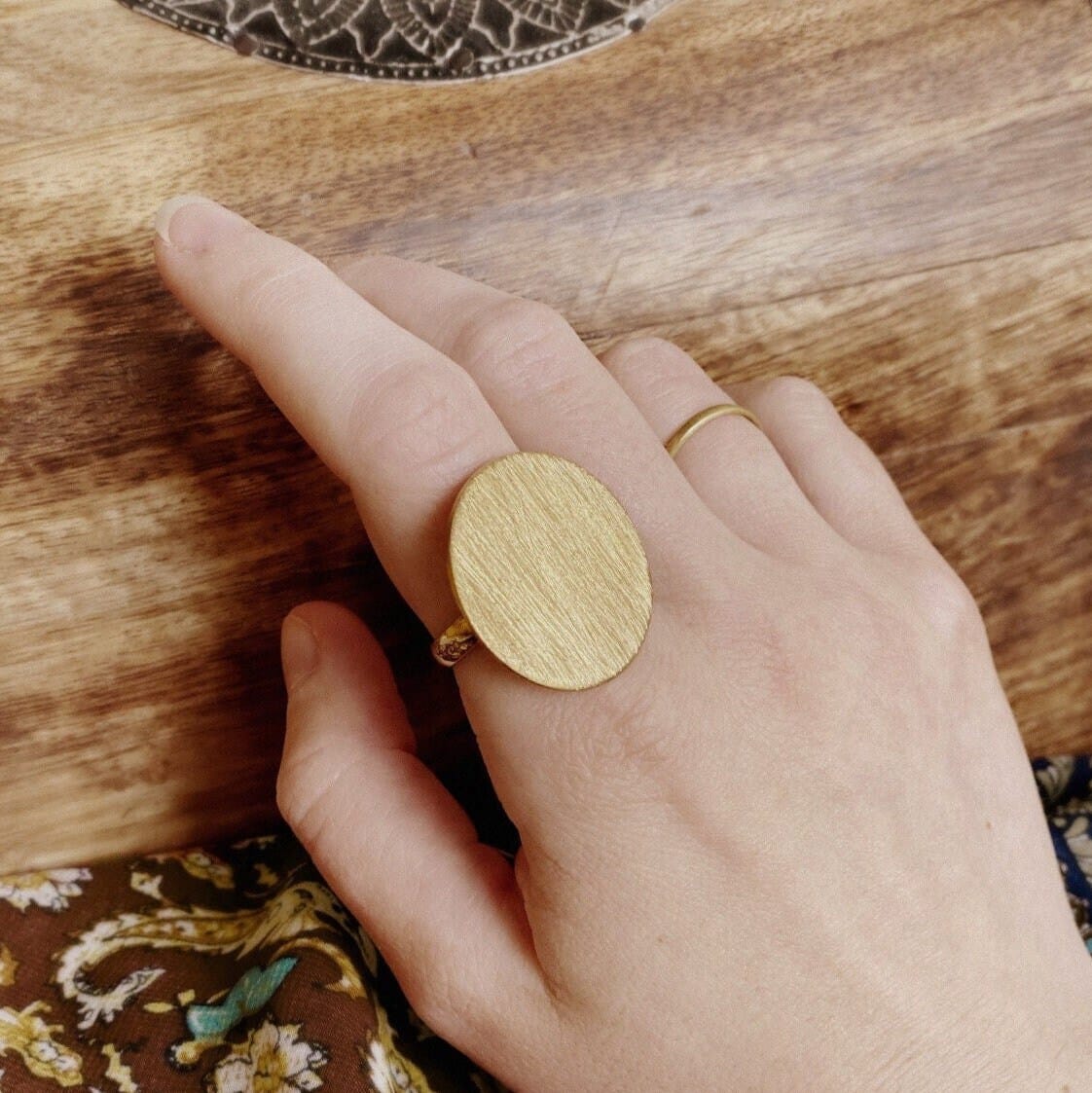 A bold and minimalist brass ring featuring a smooth, round surface, perfect for adding a touch of elegance to your everyday look