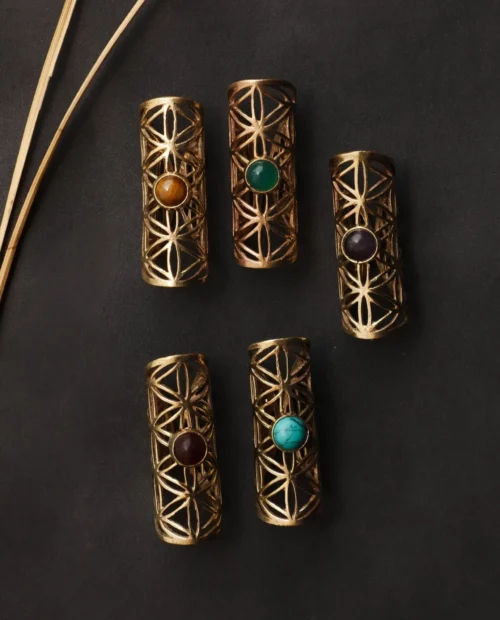 Handcrafted brass dreadlock beads from TribalDesert, featuring intricate geometric cutouts and semi-precious stones