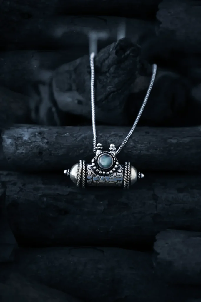 Exquisito collar de medallón tribal hecho a mano, con intrincado trabajo en plata y un fascinante centro de mesa de piedras preciosas