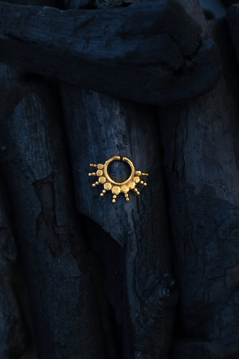 Handcrafted brass septum ring from TribalDesert, featuring a radiant sunburst design inspired by ancient tribal motifs